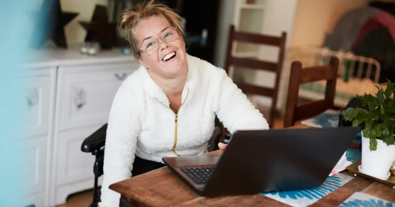 A woman sitting at a table with a laptop.